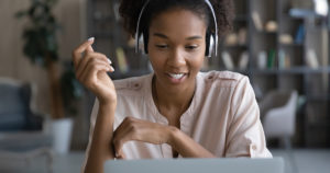 Young woman joyfully works at laptop