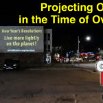 Projection on building: New Year's Resolution - Live more lightly on the planet. Projecting optimism in the time of overshoot